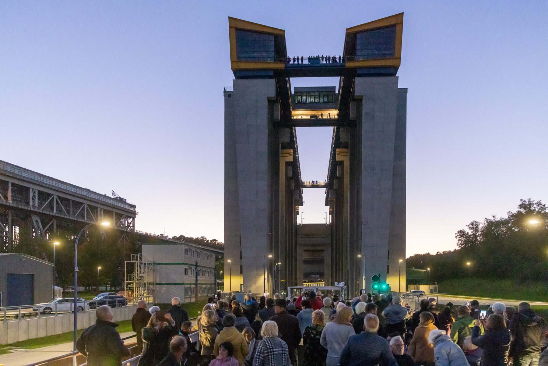 Das Neue Schiffshebewerk Niederfinow in der blauen Stunde, davor viele Zuhörer, oben auf der Brücke zwischen den Türmen weitere Menschen