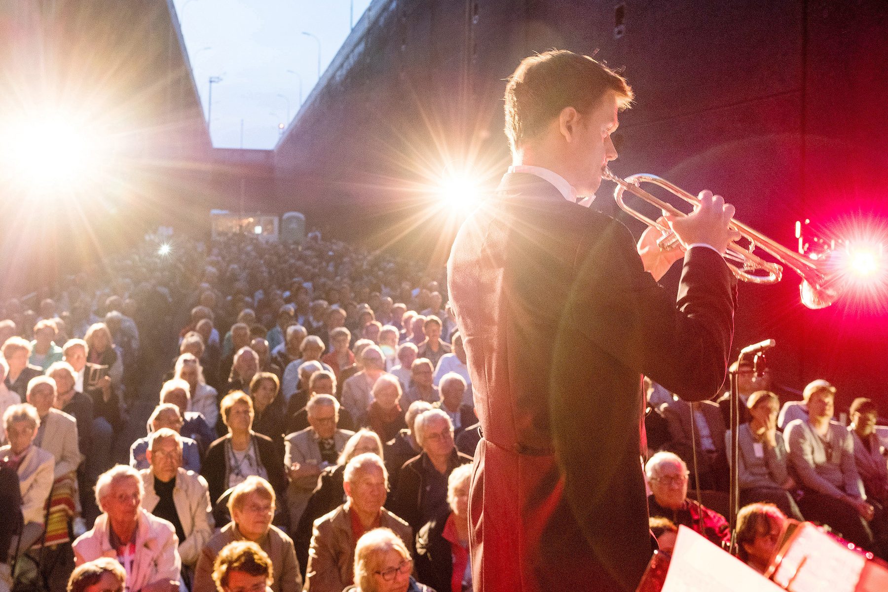 Ein Trompeter spielt im Scheinwerferlicht, davor das dicht besetzte Publikum